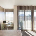 curtains hanging from the ceiling in a room with beige interior