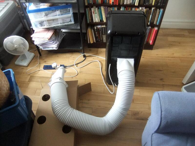 a portable air conditioner with a white exhaust hose connected to it. The pipe is designed to vent hot air, essential for the unit's operation.