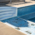 Empty in ground swimming pool ready for replacement of old vinyl lining or liner