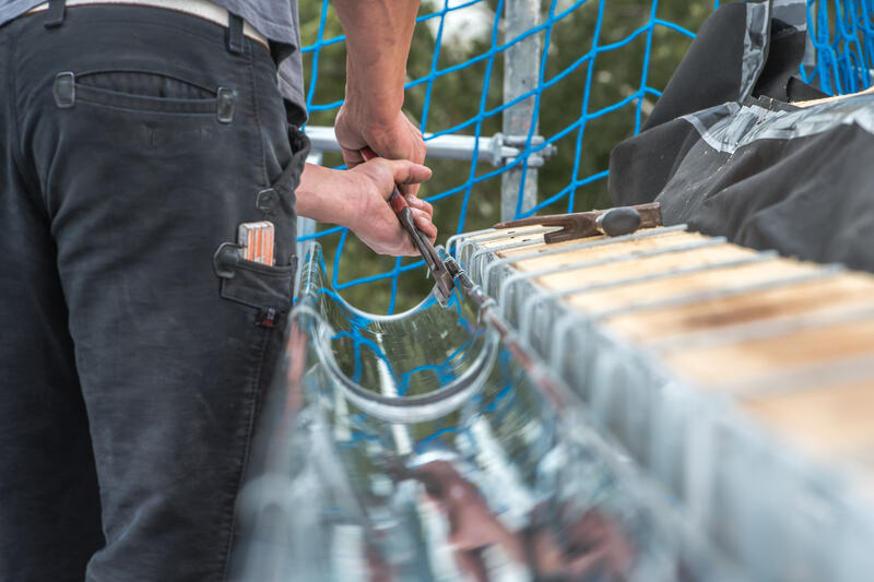 Person replacing a new gutter on a roof