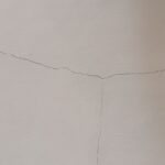 Hairline Cracks on White Plaster Wall and Ceiling Surface