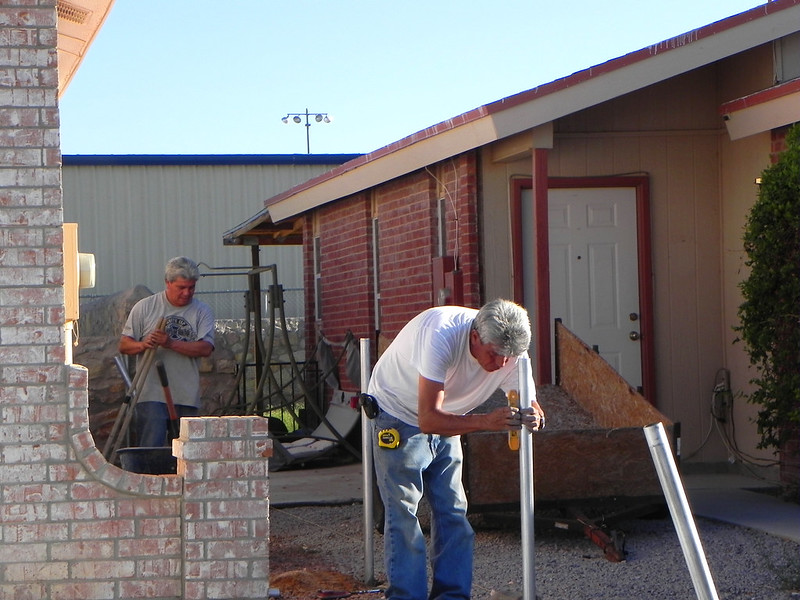 Two men installing fence posts 