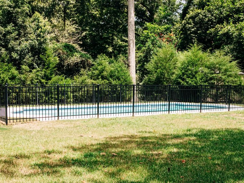 a black metal fence around a pool. 