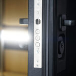 How to Soundproof a Door Door lock on a slightly open entrance metal armored door with thermal insulation and sound insulation.