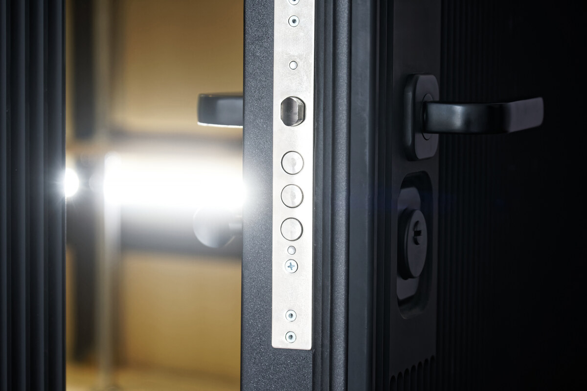 Door lock on a slightly open entrance metal armored door with thermal insulation and sound insulation.